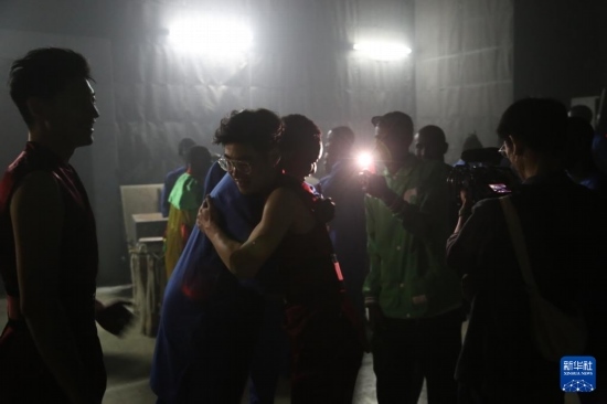 4月10日，在塞內(nèi)加爾首都達(dá)喀爾的國家大劇院，中央音樂學(xué)院進(jìn)擊打擊樂團(tuán)成員與塞內(nèi)加爾杜杜·恩迪亞耶·羅斯打擊樂團(tuán)成員在演出后臺(tái)擁抱。新華社記者 司源 攝