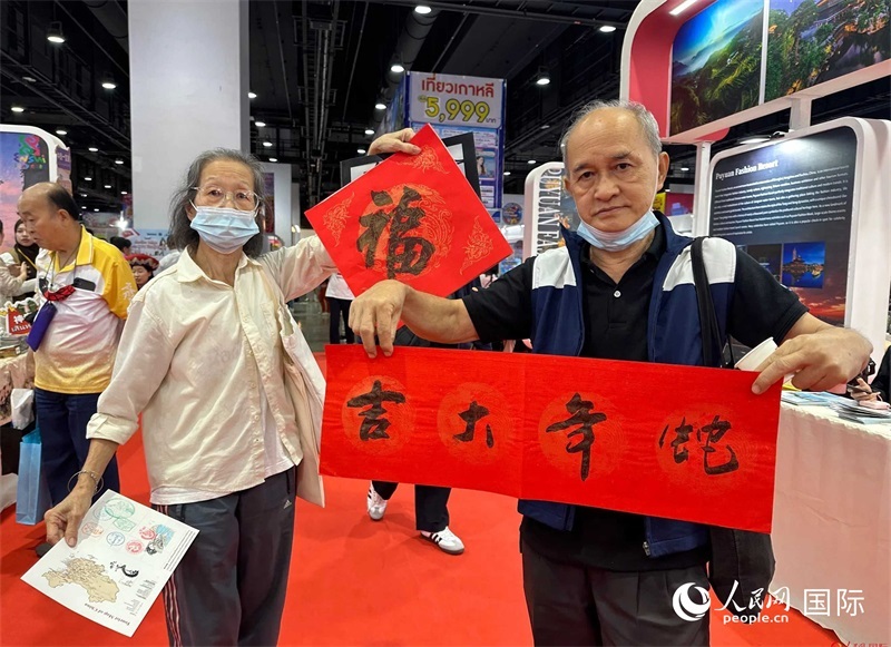 2025蛇年春節(jié)，泰國市民展示他們領(lǐng)到的華人手寫春聯(lián)。人民網(wǎng)記者 簡承淵攝