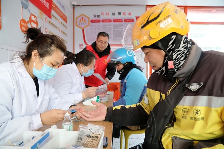 2025年3月5日，志愿者在山東省棗莊市市中區(qū)一工會驛站為外賣員免費(fèi)測量血糖。新華社發(fā)（王海楠攝）