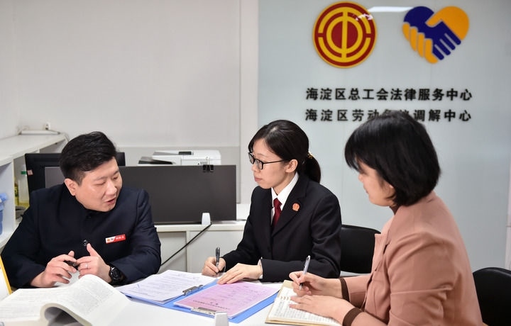2025年3月6日，在北京市海淀區(qū)總工會勞動爭議調(diào)解中心，海淀區(qū)人民法院法官王琰（中）與該中心工作人員就糾紛化解情況進(jìn)行溝通。新華社記者 趙婷婷 攝