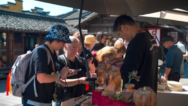 “五一”期間，游客正在烏鎮(zhèn)“水鄉(xiāng)碼頭”挑選購(gòu)買文創(chuàng)產(chǎn)品。受訪者供圖