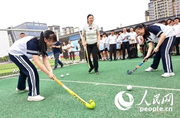 陳朝霞（中）指導(dǎo)學(xué)生體驗(yàn)曲棍球。 人民網(wǎng)記者 楊磊攝