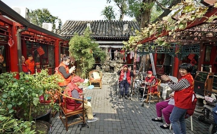 2024年10月12日，鐘樓灣胡同的老年人在社區(qū)內(nèi)的四合院養(yǎng)老驛站休閑。2017年起，北京市先后開展了兩輪背街小巷環(huán)境整治提升行動，完整保留了中軸線生活建筑群的歷史信息，并根據(jù)居民的生活和居住方式進行適配化的更新和改造，極大地改善了生活環(huán)境。2023年鐘樓灣胡同被評為“北京最美街巷”。