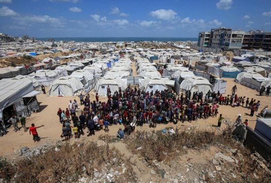 5月28日，人們在加沙城西部的沙提難民營等待領取救助食物。新華社發(fā)（里澤克·阿卜杜勒賈瓦德攝）