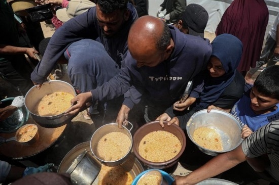 5月28日，人們在加沙城西部的沙提難民營領取救助食物。新華社發(fā)（里澤克·阿卜杜勒賈瓦德攝）