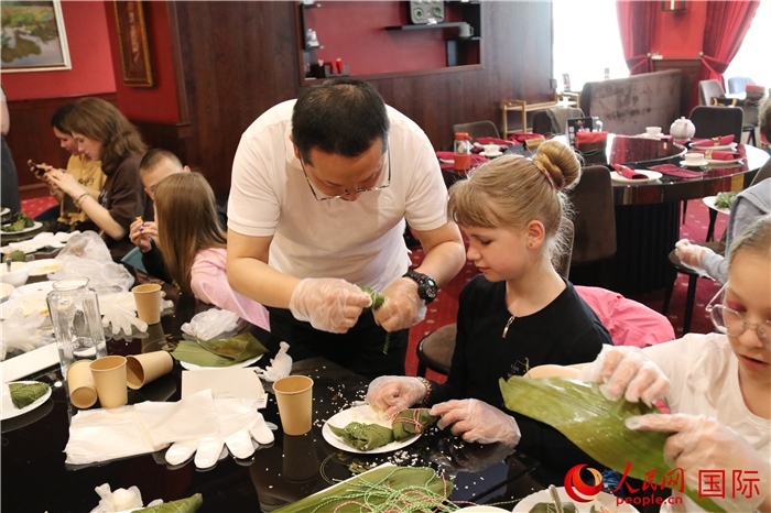 烏克蘭兒童學習體驗包粽子。人民網(wǎng)記者蔡子暢攝